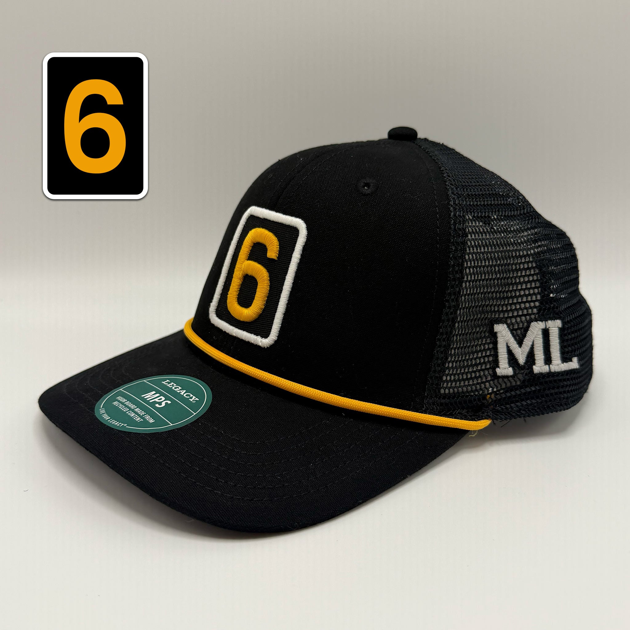 A black trucker-style baseball cap with a yellow and white embroidered number 6 on the front, a yellow trim line, white 'ML' embroidery on the side mesh, and a green size sticker on the brim. A black square graphic with a yellow number 6 is shown in the top left corner.